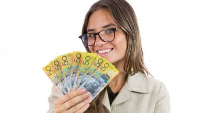 Woman holding $50 notes and smiling.